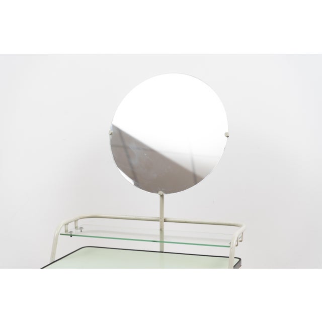 Dressing table by Auping. This piece consists of a round mirror on a metal frame. The table comes with a wooden cabinet...