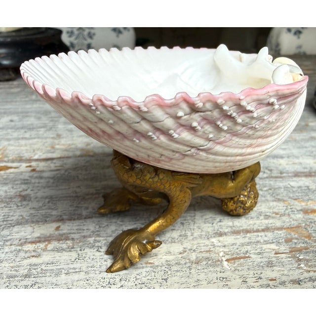 Pink French scallop shell attached to a brass pedestal featuring a mermaid. Lovely real shell. Great detailing in the...