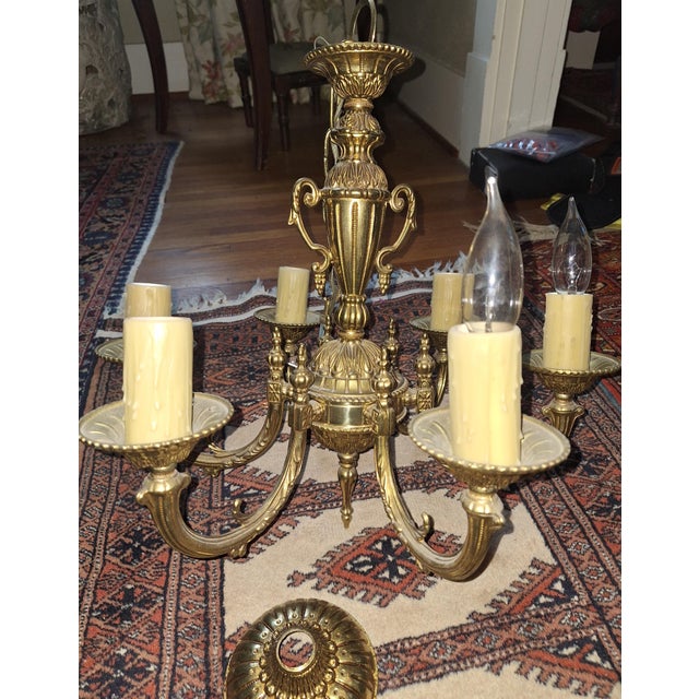 Lovely solid brass six-arm chandelier with detailed ceiling escutcheon. Wired and working. Faux drip candle socket covers...