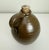 Lovely vintage or antique earthenware jug or bottle with a curved handle and cork stopper. Features a chocolate brown...