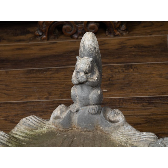 An English lead bird bath from the mid 20th century, with squirrel and bird sitting on a shell. Created in England during...