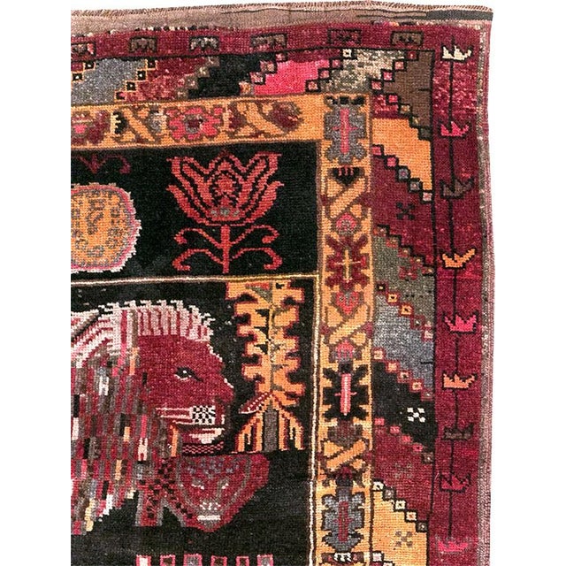 A mid-20th-century Turkish Pictorial Rug featuring 2 lions on a charcoal color field