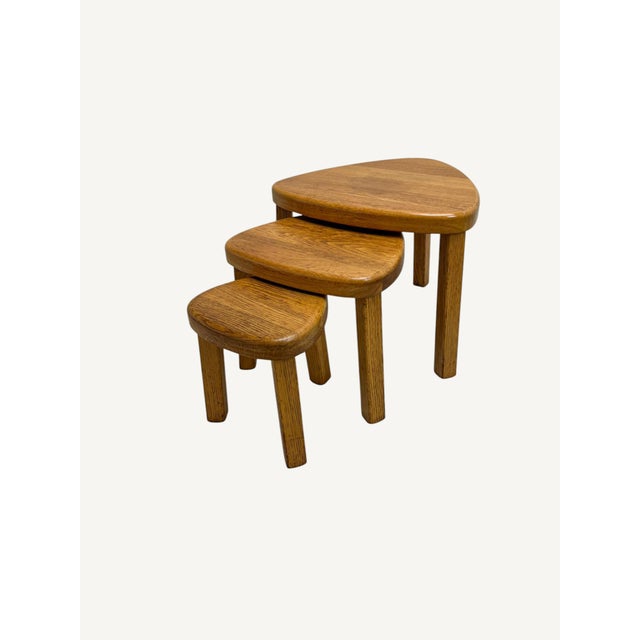 A set of three nesting tables in a warm color solid oak, oval/kidney shaped in the style of Pierre Chapo,ca 1970. Useful,...
