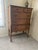 This is a five-drawer highboy/chest on chest dresser featuring burl veneer panels on the top, two small drawers and bottom...