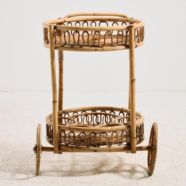 A serving cart made of natural materials from the 1960s. The frame of the trolley is made of bamboo and woven with rattan....