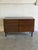 This dark rosewood sideboard pairs four stacked drawers with a full-height cabinet door. A clean rectangular case, handle-...