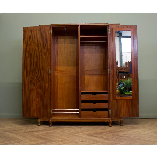 A striking 1930s Art Deco compactum wardrobe, beautifully finished in richly figured burr walnut. The stepped design...