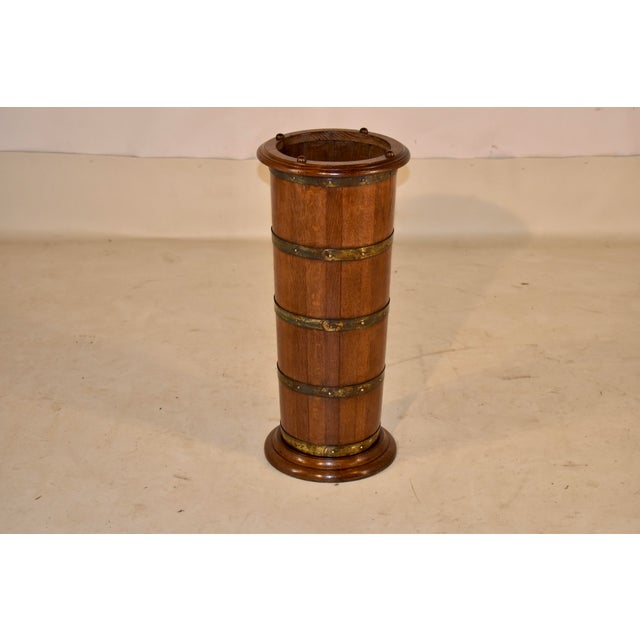 19th century oak umbrella or cane stand from England. The rim and the base are turned and the stand is made up of oak...