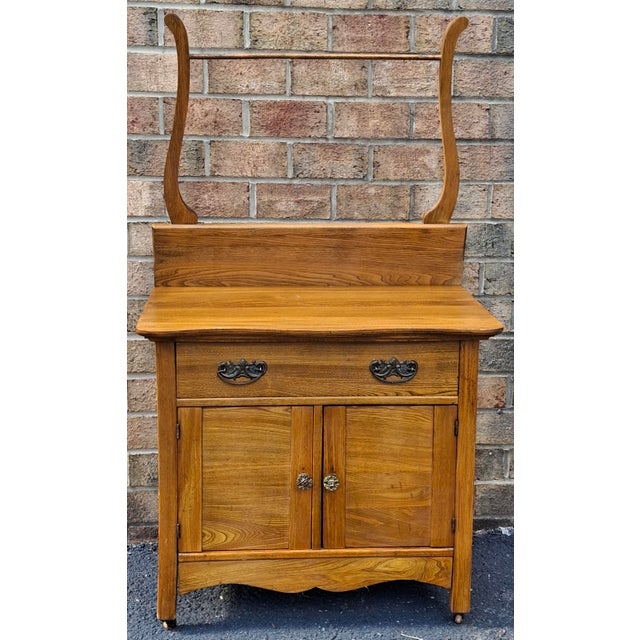 Victorian Style Oak Washstand with Towel Rack on wheels. Wooden wheels. Measures: 30" in width, 17.5" in depth and 28" in...