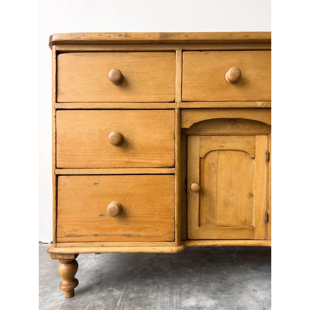 A perfectly proportioned antique English pine dresser base with ample storage. Used modernly as a sideboard, this piece of...