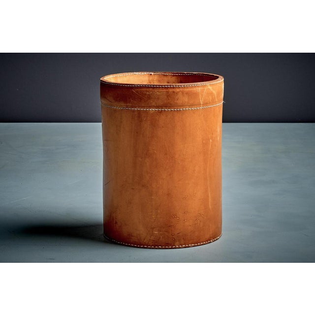 Leather paper basket, Denmark, 1960s. Cylindrical form in warm cognac leather with bold white saddle stitching, finished...