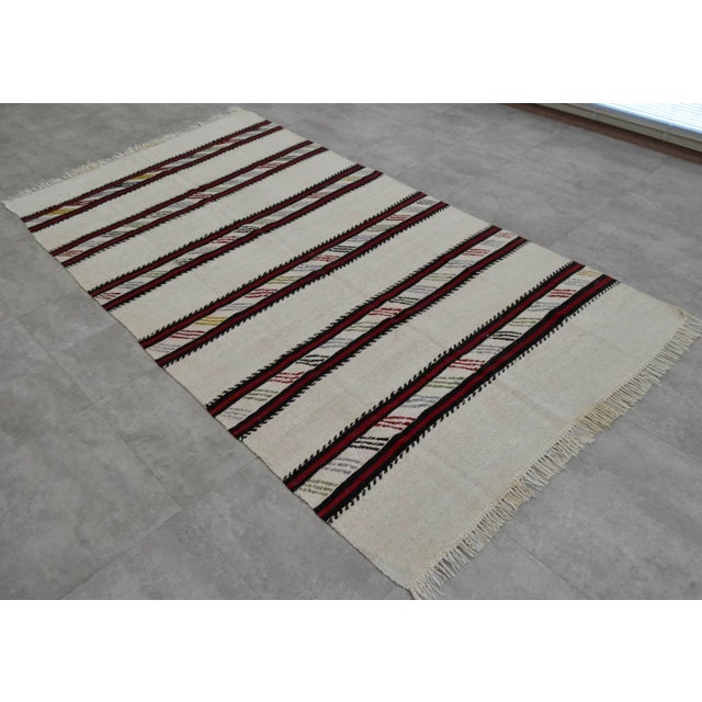 Beige background burgundy and black striped kilim rug, from Aegean Turkey. In excellent condition. Approximately 45-55...
