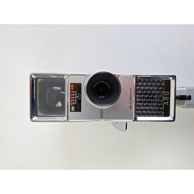 Vintage handheld film movie camera by Meopta, model A8G, produced in Czechoslovakia during the 1960s. Featuring a refined...