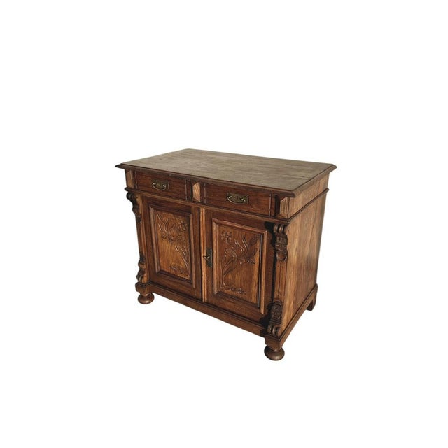 A charming antique Solid Oak French Cabinet featuring two drawers and two carved doors with floral details. Complete with...