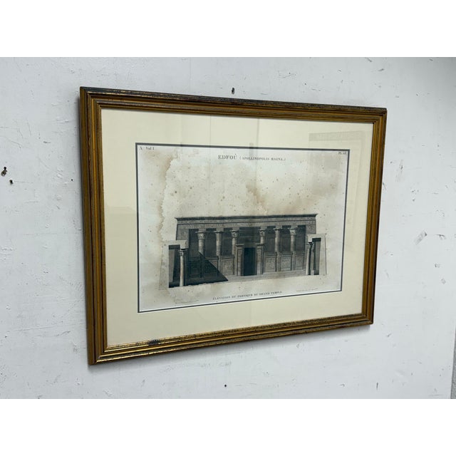 Design Plus Gallery presents an Architectural Framed Print of “Edfou (Apollinopolis Magna)” Temple Portico Elevation. The...
