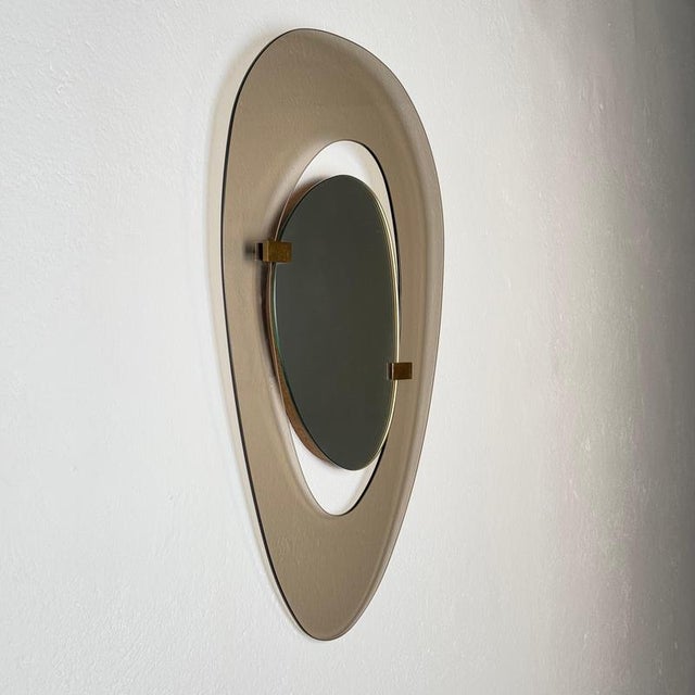 A striking asymmetrical wall mirror designed by max ingrand for fontana arte in 1958, a refined expression of post-war...