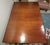This stately 1920s English gate leg dining table features a mahogany top and legs with a golden satinwood apron. The legs...