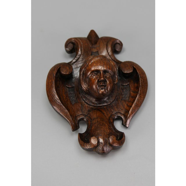 Antique French hand-carved oak wood wall plaque with cherub's head, ca. 1900. An adorable Baroque-style hand-carved dark...