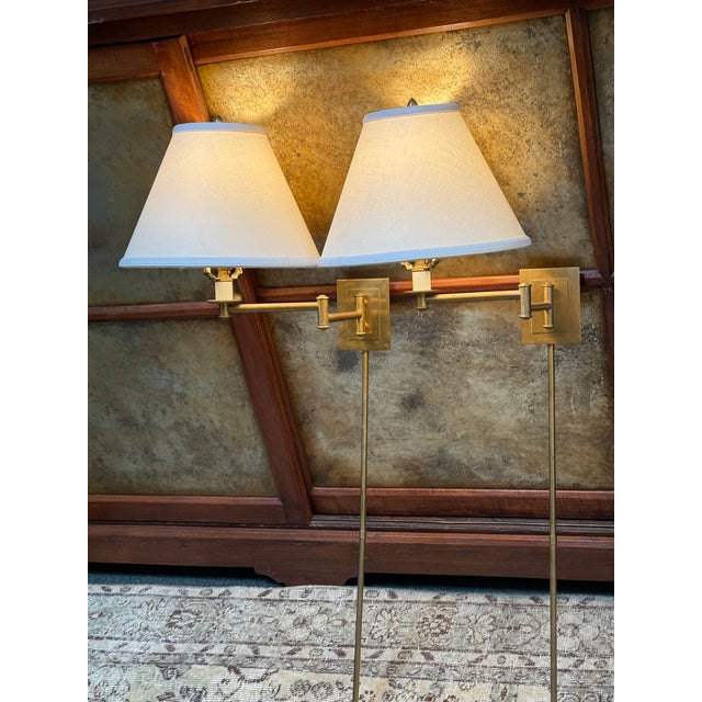 Design Plus Gallery presents a Pair of Primitive Swing Lamps from Visual Comfort. Each lamp displays an articulated brass...