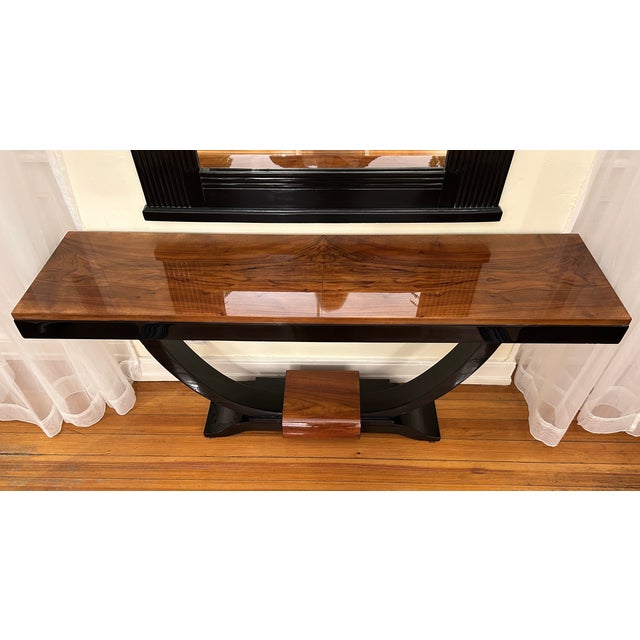 This classic Art Deco console table from France features a walnut veneer and contrasting elements finished in high-gloss...