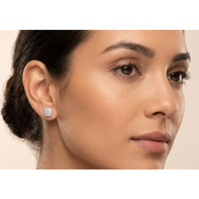 Elegant 14K white gold stud earrings featuring pave-set brilliant round diamonds totaling 1.5 carats. Estate piece with...
