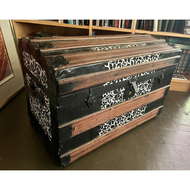 This lovely steamer trunk features an embossed metal finish with a black and white floral design. It has wheels for easy...