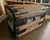 This lovely steamer trunk features an embossed metal finish with a black and white floral design. It has wheels for easy...