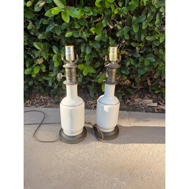 Beautiful matching pair of vintage porcelain table lamps featuring romantic courting scenes, elegant gold-tone trim, and...