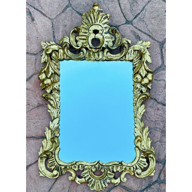 This decorative wall mirror is crafted in molded plaster and finished with a gilt surface, designed in the Baroque style....