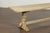 A French bleached walnut bench from the 19th century with trestle base made of two turned baluster legs connected to one...