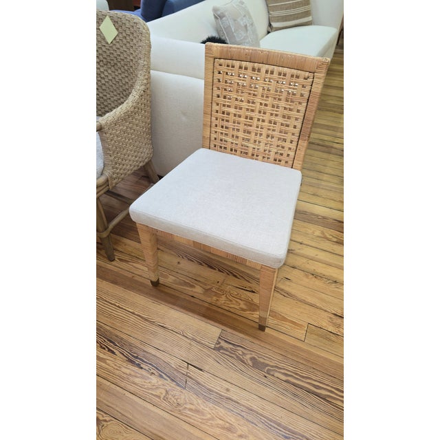 This Kravet rattan side chair features a natural woven construction with a structured back and an armless silhouette,...