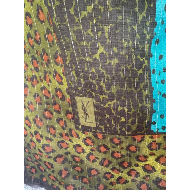 Large vintage YSL leopard print scarf in shades of khaki green, brown, yellow, and bright blue. The prints are varied and...