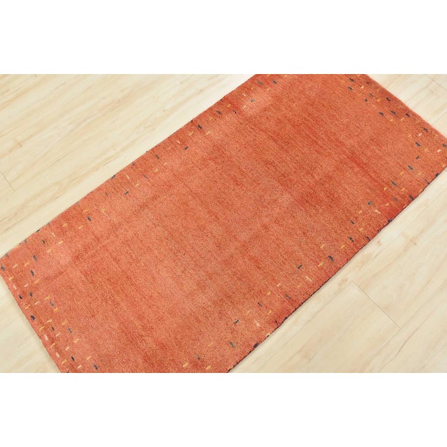 A contemporary Gabbeh rug hand-knotted with an all-wool pile on a cotton foundation. This finely woven rug features a...