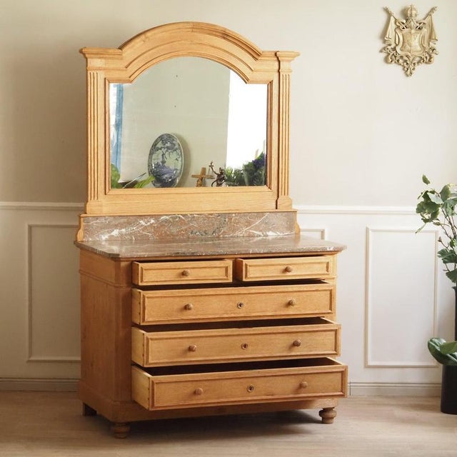 French oak chest of drawers with a marble top and mounted mirror, stylistically dating to around 1920. Light and natural...