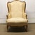 19th Century wing back chair with cream colored floral and ribbon upholstery and a carved floral wood frame. There is...