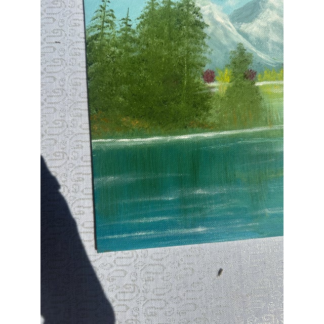 Up for consideration is a beautiful vintage riverside and mountains landscape painting with colorful bushes on canvas....