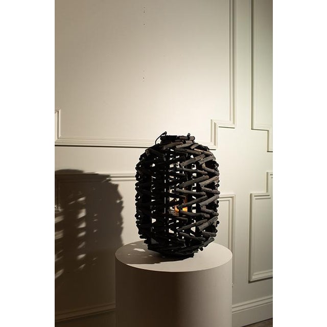 Add a touch of rustic sophistication to your space with this striking woven wood lantern. Handcrafted with a textured,...