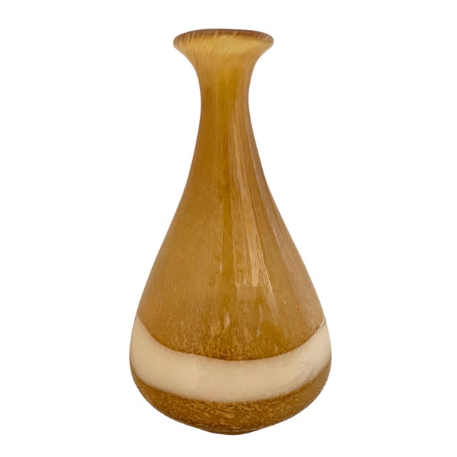 This vintage hand-blown amber glass vase features a stunning Murano-style design with amber and white swirling patterns,...