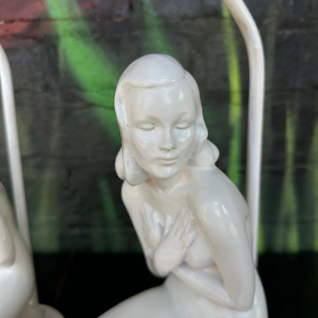 This is a pair of Art Deco nude table lamps. They feature a plaster molded nude woman in a crouched position covering her...