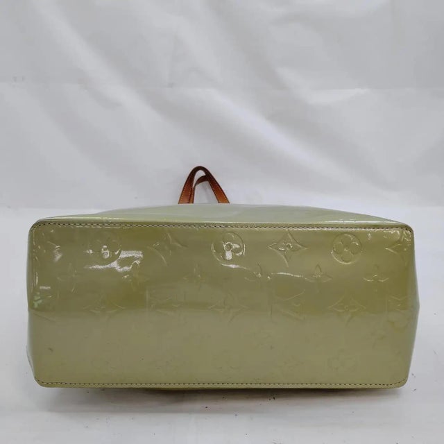 This sophisticated Louis Vuitton Reade GM handbag is a stunning example of the French luxury house's Monogram Vernis line....