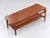 Vintage teak coffee table featuring a stylish and functional design. The table is equipped with a reversible top, allowing...