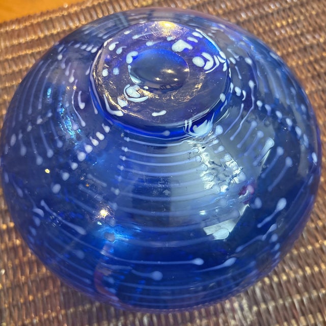 Mikasa "Cascade Blue" vase. It is characterized by its round, bulbous shape and intricate internal white swirl or...