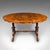 This is an antique display table. An English, burr walnut and mahogany four seat oval centre table, dating to the early...