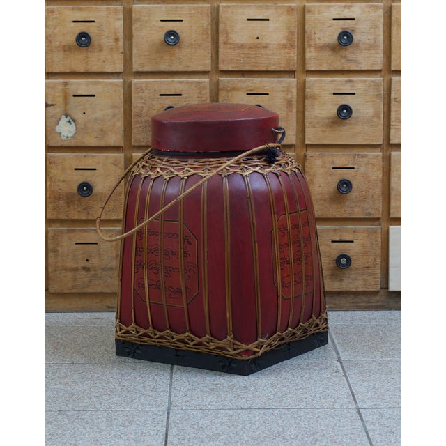 A beautiful Asian rice container in smoky red. Burma, mid-20th century. Made of bamboo, with a bamboo-wrapped handle....