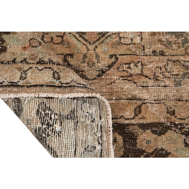 Beautiful vintage chic hand-knotted wool rug featuring a tan and peach medallion design with a distressed finish.. This...