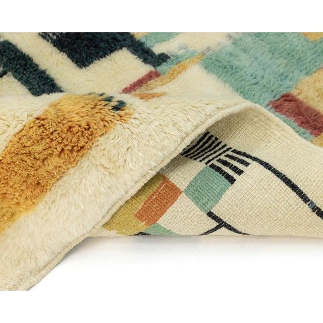 Stunning hand-knotted rug featuring a captivating geometric abstract design in a vibrant color palette, including shades...