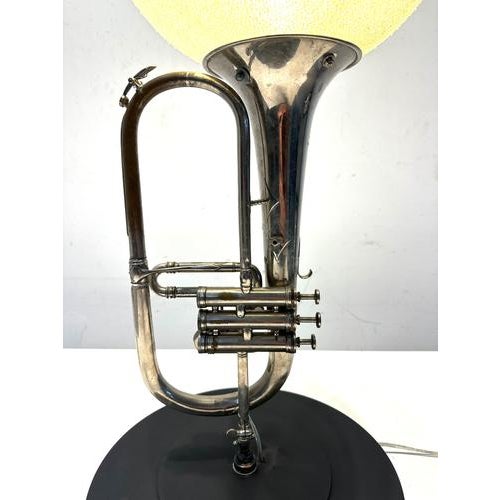 Striking vintage table lamp created from a silvered trumpet, combined with a large spherical yellow glass shade. The...
