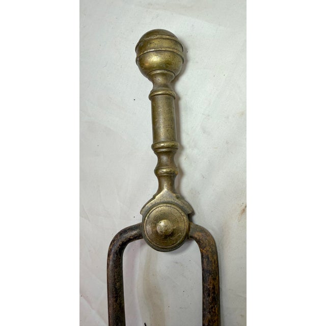 Up for sale is a pair of rare antique 18th century wrought iron and brass English fireplace tongs. The arms are wrought by...