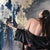 This artwork depicts a figure in a flowing black garment adorned with floral motifs, captured in a moment of graceful...