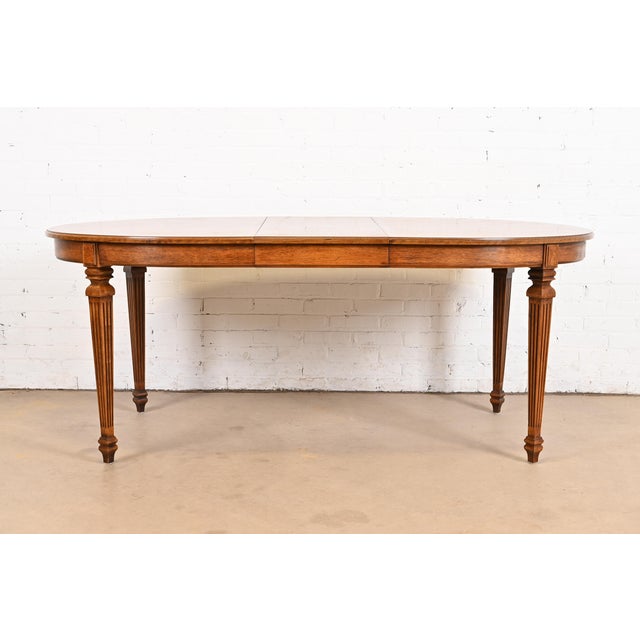 A beautiful French Regency Louis XVI style extension dining table By Thomasville USA, Circa 1960s Carved walnut, with...